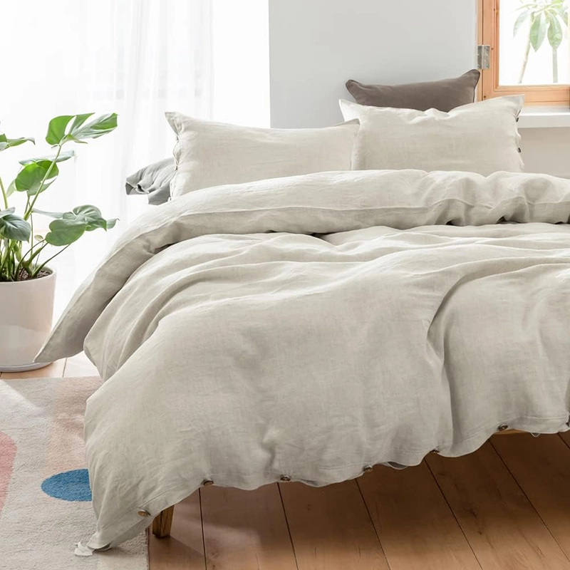 Linen bedding in a naturally-lit bedroom with plant accents, creating a fresh and airy atmosphere.