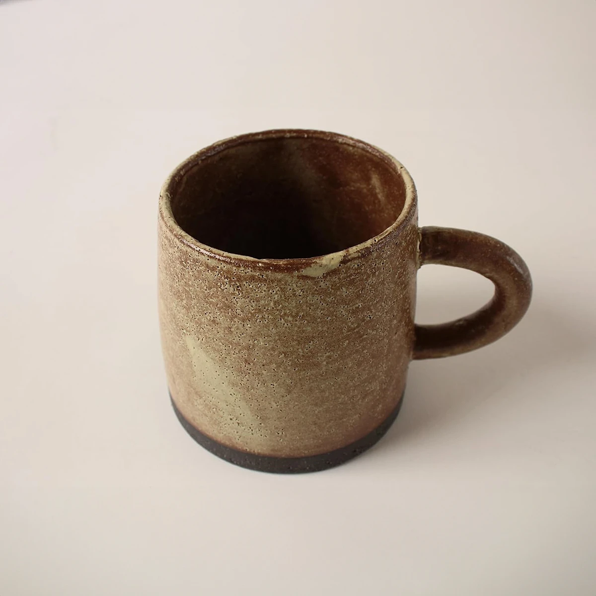 Japanese Mino ware mug in peanut brown and ocher, showcasing the traditional tapered shape and unique glaze lines, handcrafted in Japan.