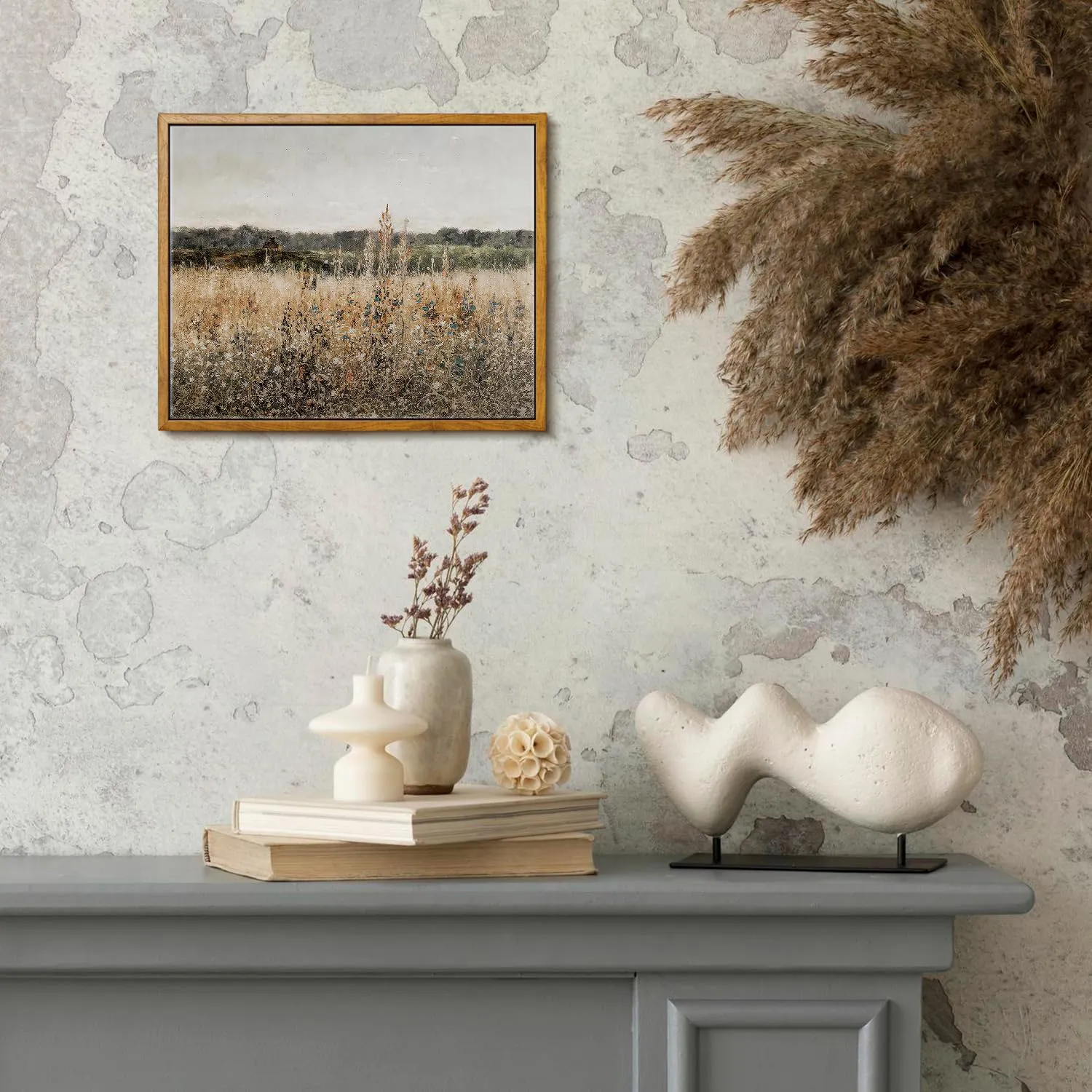 A vintage-style framed canvas depicting a French Champ Fleuri landscape on a mantelpiece adorned with elegant vases and dried botanicals.